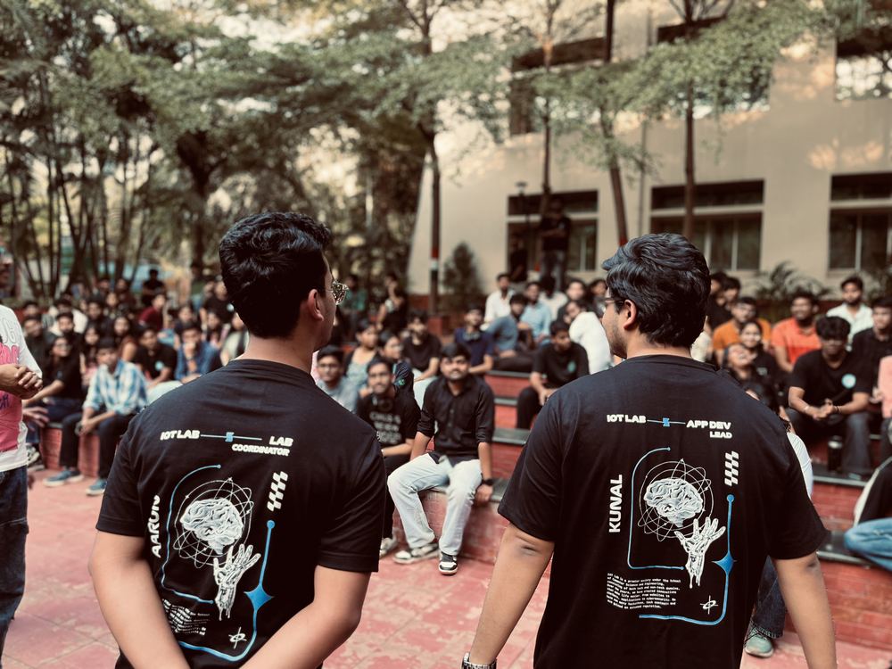 Aaron and the app dev lead in custom coordinator tees, facing the crowd at a lab event